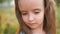 Wonderful close portrait of a beautiful little girl with long hair and gray eyes. Against the backdrop of a summer