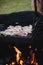 Wonderful detail of grilling pork neck meat on a granite stone laid on the heat of the fire. Meat sprinkled with salt, basil,