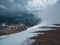 Wonderful dramatic landscape with big snowy mountain peaks above low clouds. Snow storm on top of a mountain. Atmospheric large