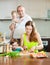 Wonderful family of four cooking red fish in the home kitchen