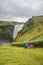 Wonderful, high and huge Skogarfoss waterfall and camping site with tents on South Iceland, summer