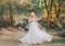 Wonderful lady in blond curly hair in a gray luxurious flying gorgeous and fluttering wedding dress with flowers, mesh