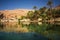 Wonderful lake and oasis with palm trees in the Omani desert and overwritten text