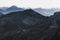 Wonderful landscape of mountain ranges and peaks. A view of the misty slopes, silhouette, and layers mountains at distance. Alps.