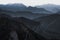 Wonderful landscape of mountain ranges and peaks. A view of the misty slopes, silhouette, and layers mountains at distance. Alps.