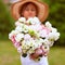 A wonderful large bouquet of white-pink peonies in the hands of a girl.