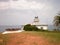 Wonderful Lighthouse With A Boat At Its Doors In Candas.