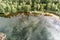 Wonderful look from above on the shore of a pond, with reflexion of the clouds in the water