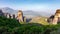 Wonderful Panoramic view of Meteora. Majestic sunny landscape with colorful sky over the fairytale mountain valley in