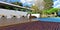 Wonderful patio with sun loungers on a wooden deck near the pool in front of a modern stylish house with a flat roof and white