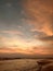 Wonderful relaxation on the evening shores of the Indian ocean, looking at the waves, colored clouds that reflect on the wet sand.