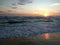 Wonderful relaxation on the shores of the Indian ocean, looking at the waves, colored clouds that reflect on the wet sand.