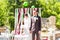 Wonderful stylish rich happy bride and groom at a wedding ceremony in green garden near wedding arch