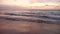 Wonderful sunset with ocean waves on empty sandy beach