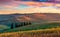 Wonderful tuscanian view with field of wheat. Marvelous summer sunrise of Italian countryside. Traveling concept background, Italy