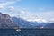 A wonderful view of a sea yacht sailing on a picturesque background of snow-capped high mountains and a blue sky