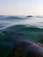 Wonderful view of the surface of the water. Through the clear water with blue and green shades you can see the seabed with rocks,