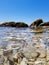 Wonderful view of the surface of the water. Through the clear water with blue and green shades you can see the seabed with rocks,