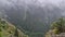 Wonderful view to the misty valley from the top of the mountain. Foggy clouds above the coniferous woods in Carpathians ridge