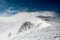 Wonderful view on winter mountain landscape and tourists on the snowy mountain ridge.