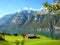 Wonderfully panorama view with a turquoise blue swiss lake with snow-covered mountains and wooden houses