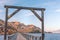 Wood archway over former train trestle bridge converted to walking and biking trail with lake and mountains in distance at sunset