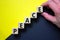 Wood blocks with word `peace` stacking as step stair on paper yellow and black background, copy space. Male hand