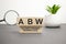 On a wood board, wooden word cubes are arranged in the letters ABW. It is an abbreviation for Activity Based Working