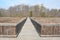 Wood boardwalk with brown plants in wetland