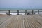 Wood boardwalk and railing by azure blue Mediterranean sea and c