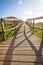 Wood boardwalk in sunny day on fields background