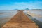 Wood bridge over land extends into the sea during ebb tide time