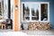 wood cabin porch with stacked firewood and snow