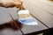 Wood carpenter applies a protective layer of transparent varnish. Hand with a brush close up on the table top