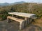 Wood and cement picnic table and green plants