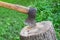 The wood chopper sticks out in wooden hemp. Ax and ax handle. Woodworking. Deforestation by a sharp axe. Ax to chop wood. Rusty bu