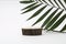 Wood circle disc platform podium and palm leaf on gray light copy spase background. Minimal empty display product presentation