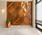 Wood cladding wall, tall planter with bushes, modern glass tall chandelier, and white marble floor