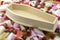 Wood coffin on top of pile of assorted sweets, junk food and candy concept for death caused by diabetes and metabolic disease,