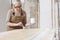 Wood crafts, woman artisan carpenter painting with brush and paint jar white the door in workshop, wearing overall and eyeglasses