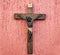Wood crucifix on a pink background