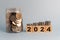 wood cube block 2024 business growth concept. New year business goals, plan and strategy. business finance coin investment, saving