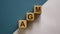 Wood cubes with acronym `AGM` - `annual general meeting` on a beautiful white and blue background. Business concept, copy spac