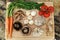 Wood cutting board in kitchen table with fresh ingredients carrot, mushroom, potatoes, tomatoes, food many colors orange, red.