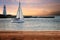 Wood deck with sailboat and lighthouse at sunset