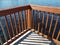 Wood fence and railing and shadow and water