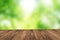 Wood floor over green forest bokeh background