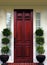 Wood Front Door on upscale home with topiaries