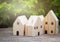 Wood house model on table  with green nature blur Background and sunray. Savings Plans for Housing. Finance and Banking