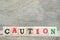 Wood letter block in word caution on wood background